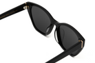 Close-up of KayTran Eyewear’s Taylor - Polished Black sunglasses with dark lenses and gold temple accents.