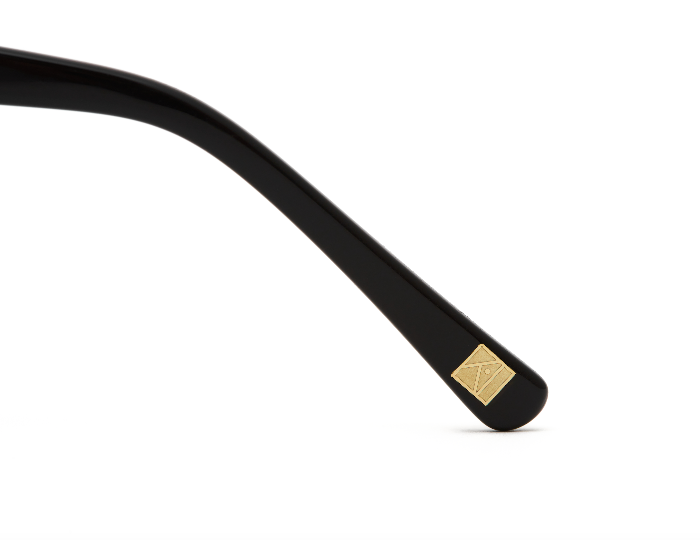 Close-up of KayTran Eyewears Harper - Polished Black arm with a gold square detail, on a white background.