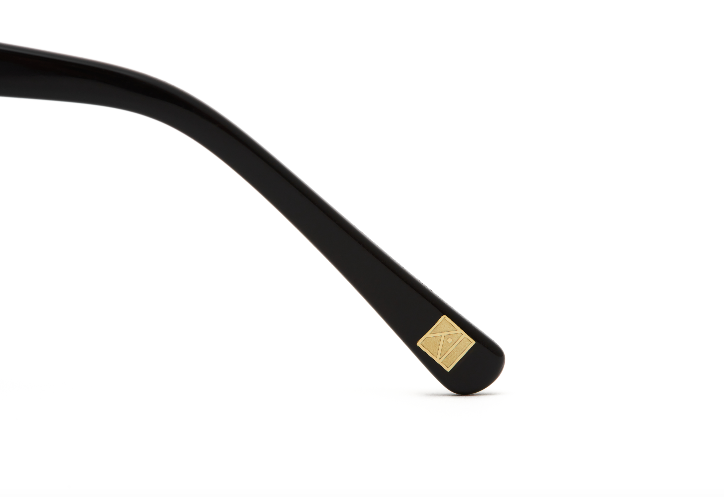 Close-up of the KayTran Eyewear Taylor Optical - Polished Black arm, with a small gold square embellishment near the tip.