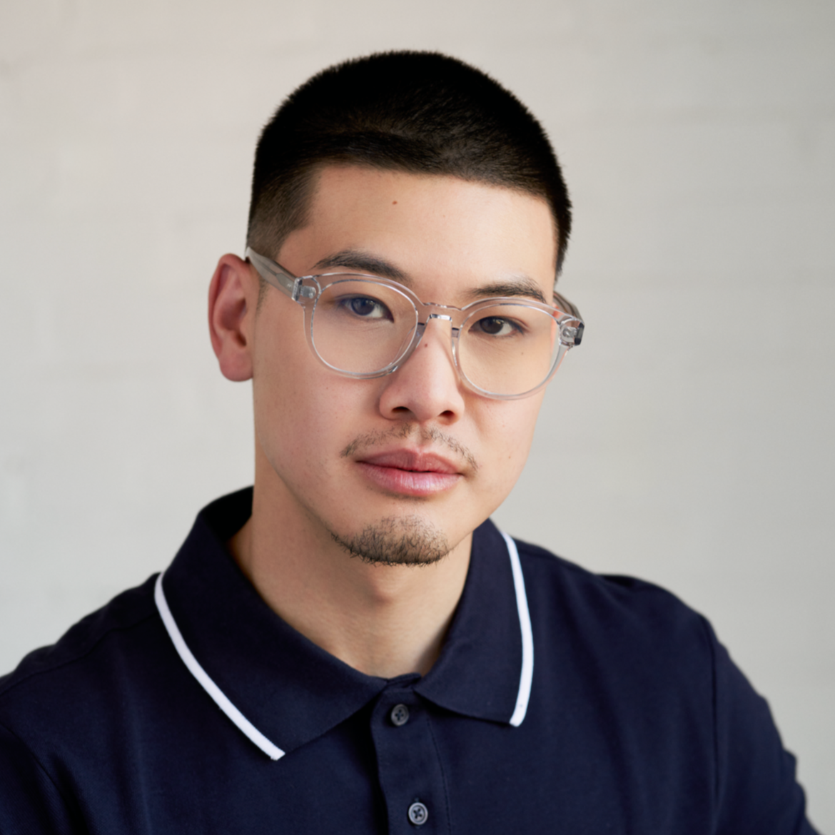 A man with short hair wears KayTran Eyewears Reese Optical - Fog glasses, facing the camera against a light backdrop.