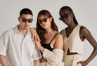 Three people wear KayTran Eyewear’s Charlie - Dark Denim sunglasses with neutral outfits against a plain background.