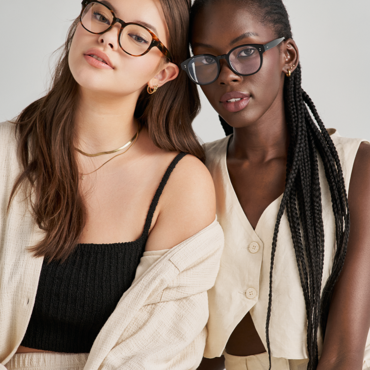 Two women wear KayTran Eyewears Reese Optical - Fog glasses with neutral outfits, facing the camera.