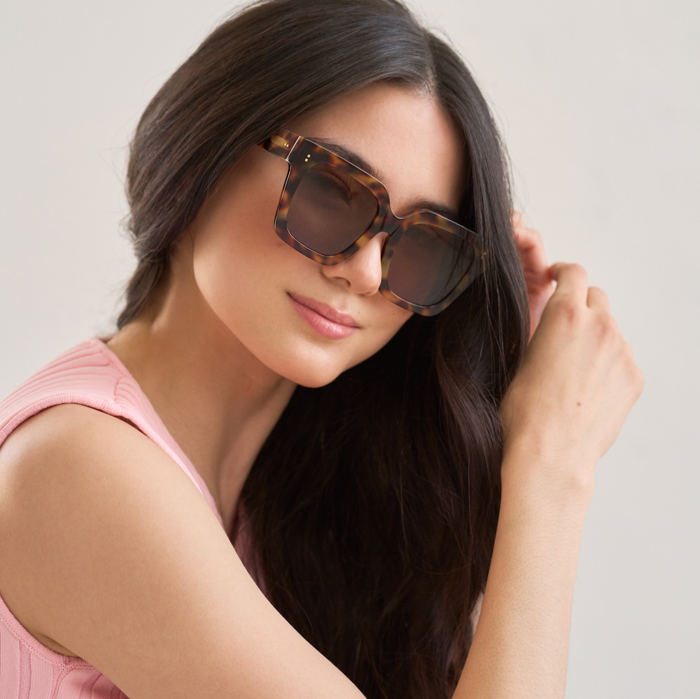 Woman with long dark hair wearing KayTran Eyewear Logan - Ember & Brown Lens sunglasses and a pink top.