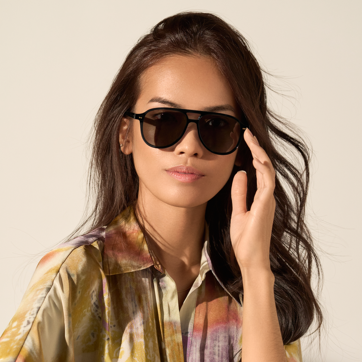 Woman with long, wavy hair wears KayTran Eyewears Knox - Monochrome sunglasses, staring at the camera.