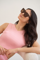 Woman in a pink ribbed sleeveless top wears KayTran Eyewears Logan - Ember & Brown Lens sunglasses, looking upward.