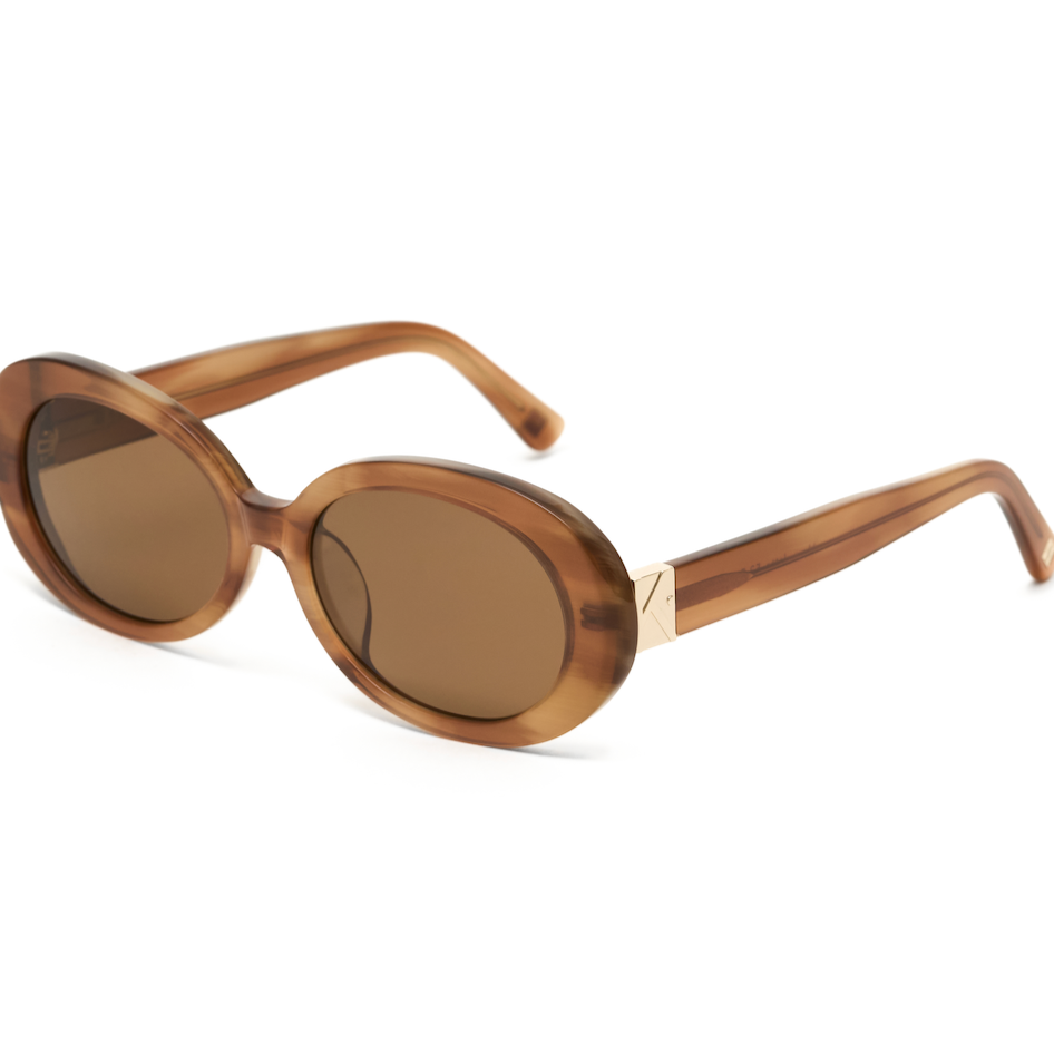 Mara - Latte oval sunglasses by KayTran Eyewear, thick frames and tinted lenses, shown on white background.
