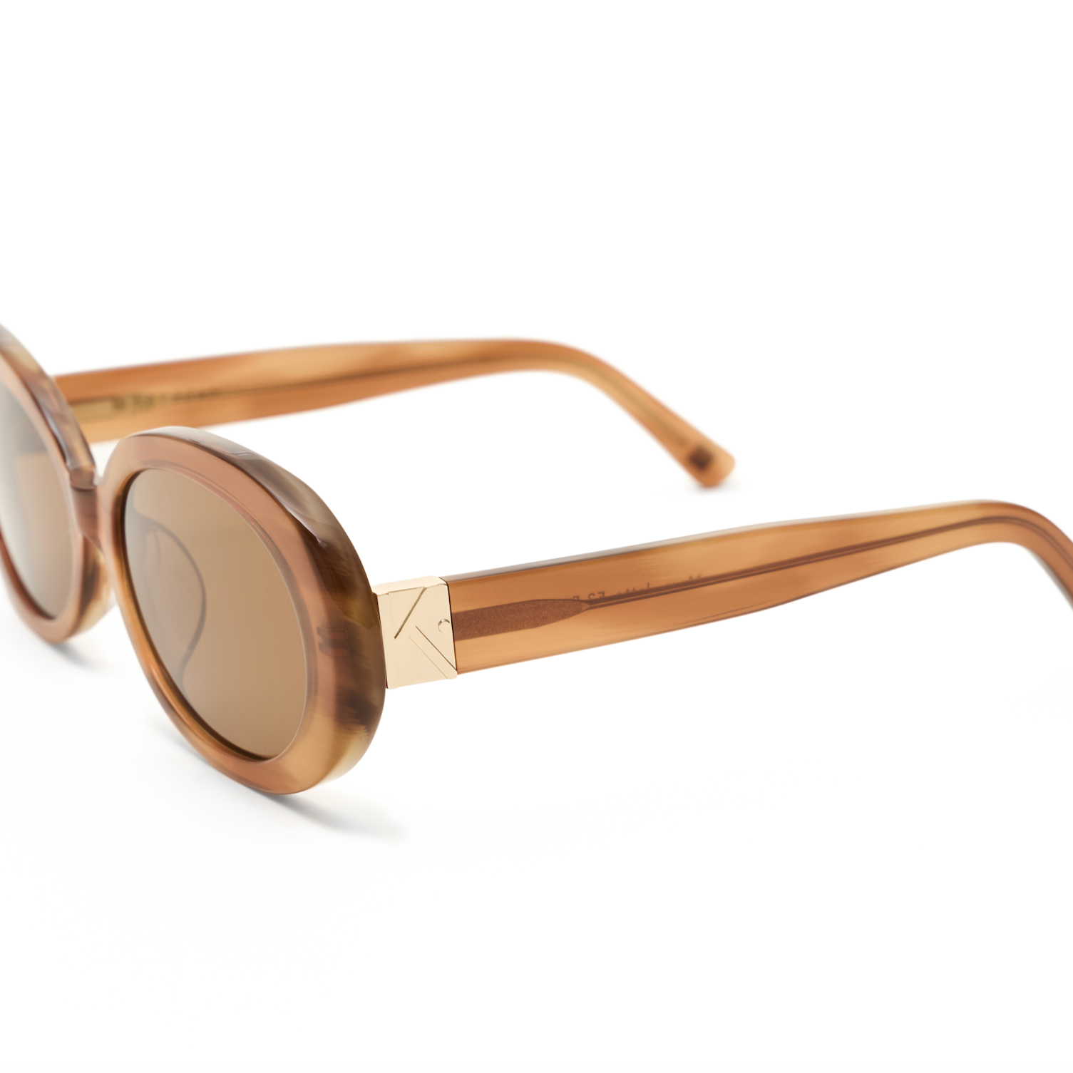 Mara - Latte by KayTran Eyewear: brown oval sunglasses with gold accents, displayed on a white background.