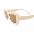Brooks - Ecru by KayTran Eyewear: cream rectangular sunglasses with brown lenses, gold hinge detail, on white background.