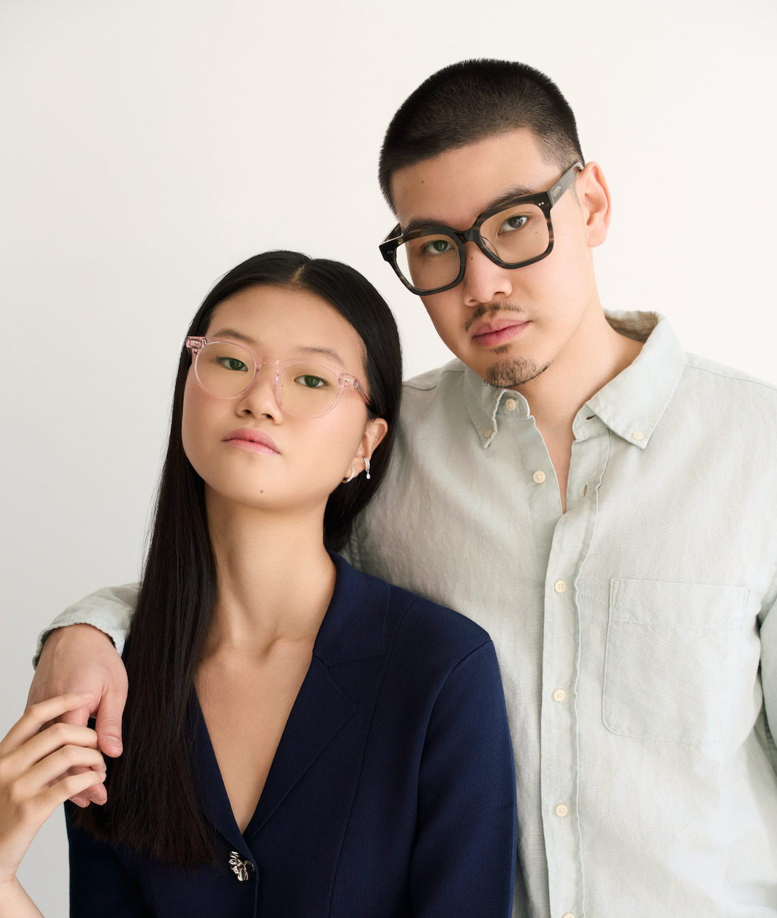 Two people wear KayTran Eyewears Bailey - Pastel Pink glasses, posing together against a plain background.