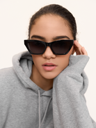 Person wearing KayTran Eyewears Kai - Polished Black sunglasses, looking at the camera with a neutral expression.