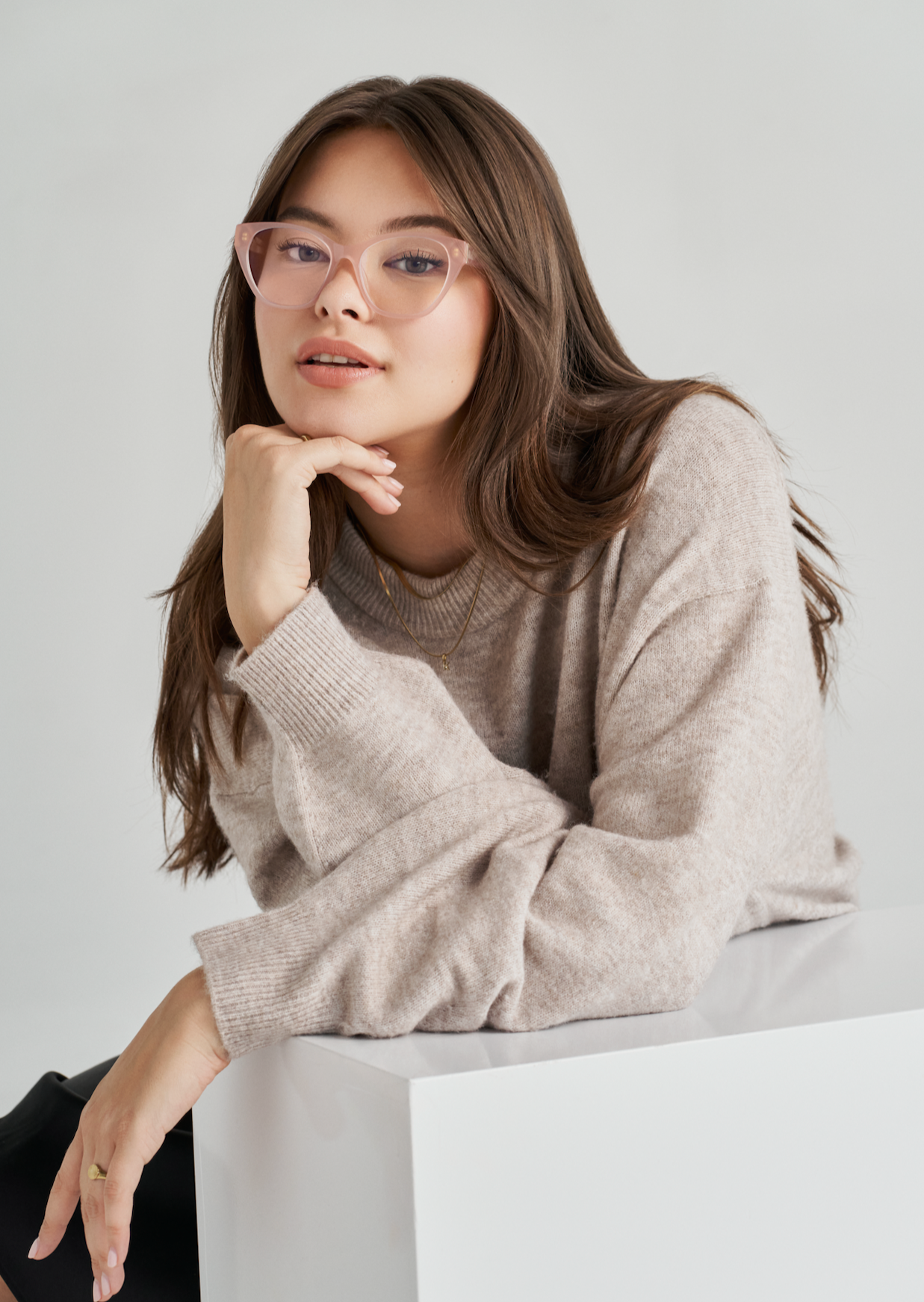 Woman with long brown hair wears KayTran Eyewears Taylor Optical - Milky Blush glasses and a beige sweater.