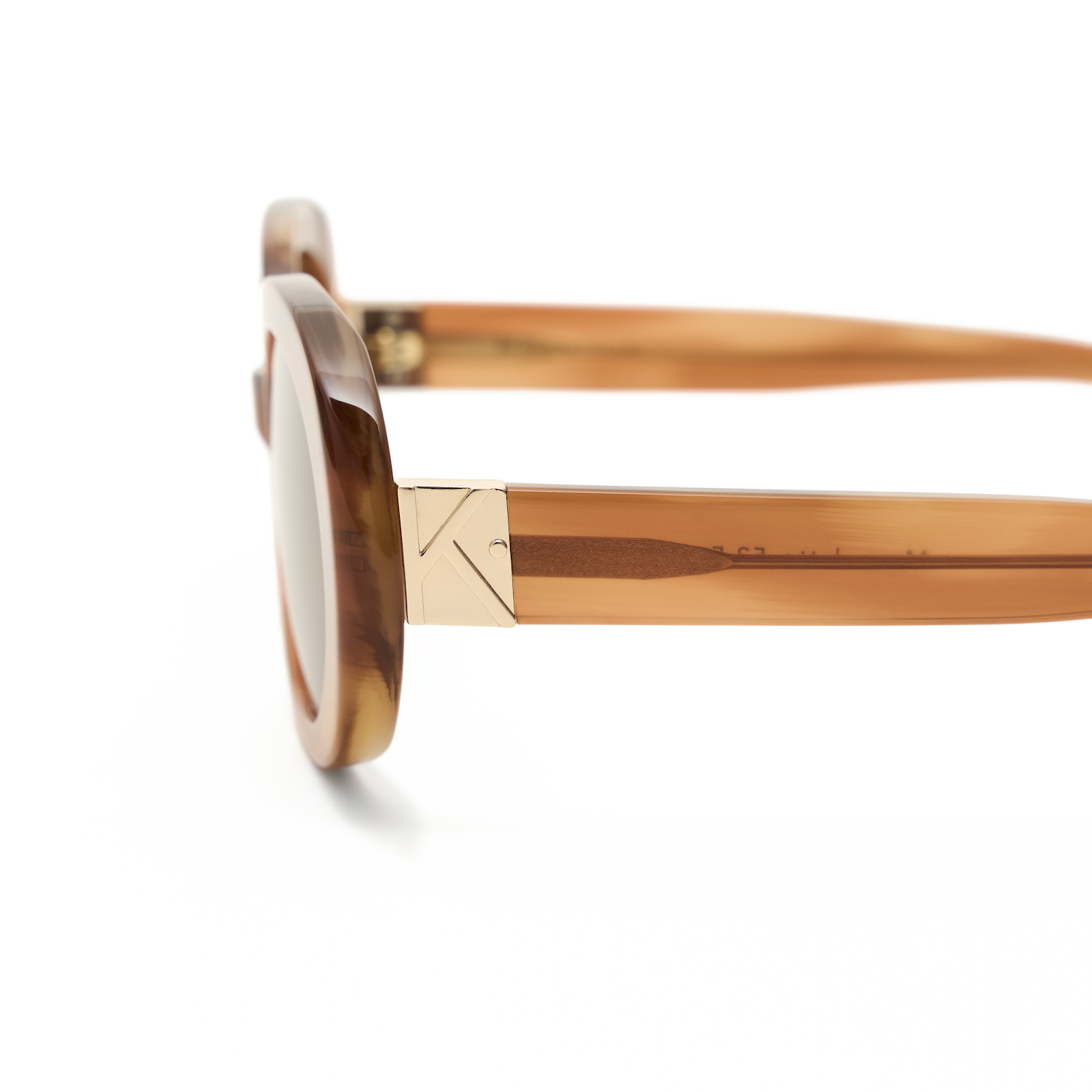 Close-up of Mara - Latte by KayTran Eyewear, brown acetate frames with gold hinge detail on white background.